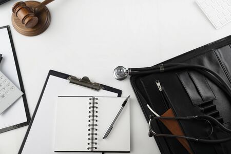 Medical law concept. Gavel, notebook and stethoscope on the white table. Place for text.の写真素材