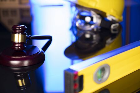 Construction law. Helmet and gavel on the blue background.の写真素材