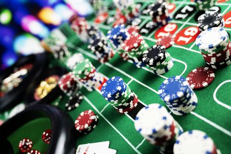 Casino felt green table with red and black numbers. Stack of poker chips.