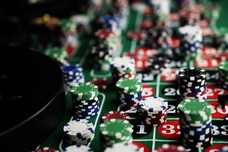 Casino felt green table with red and black numbers. Stack of poker chips.の写真素材