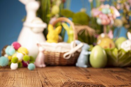 Happy Easter background. Bouquet of spring flowers. Easter decorations and Easter eggs in basket on rustic wooden table.の写真素材