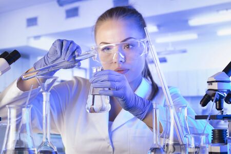 Laboratory interior. Science research concept. Young scientist during experiment and using...