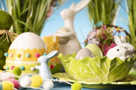 Easter theme. Easter decorations. Easter eggs in basket and cabbage leaf. Bouquet of spring flowers....
