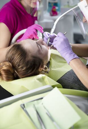 Dentist examing female patient in dental clinic. Modern medical equipment.の写真素材