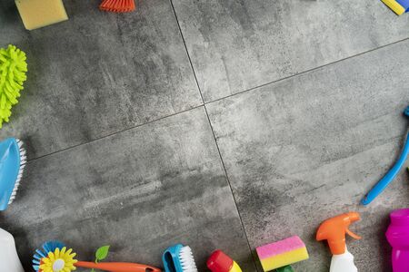 Spring house cleaning. Colorful cleaning kit on gray tiles floor. Top view.の写真素材