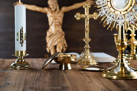 Catholic religion symbols. The Cross, monstrance, Jesus figure, Holy Bible and golden chalice on the...