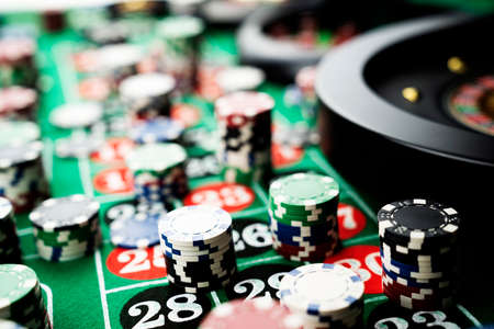 Casino theme, close up of roulette, red and black numbers. Stack of chips in the background.の写真素材