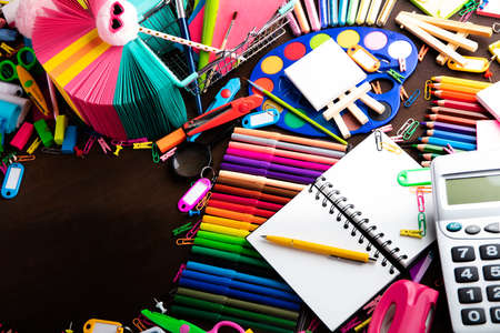 School supplies. Set of colorful school accessories isolated on the brown table. Top view.の写真素材