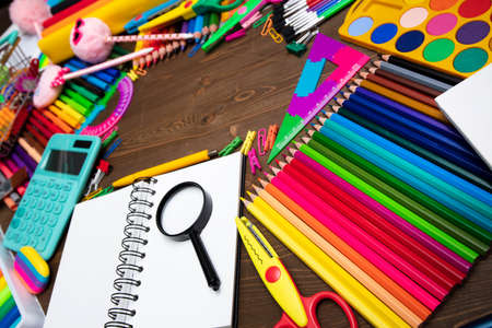 School supplies. Composition of colorful school accessories isolated on the brown table. Top view.