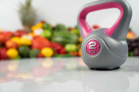 Fitness concept. Healthy nutrition: fruits and vegetables. Equipment for fitness exercises: weighing...