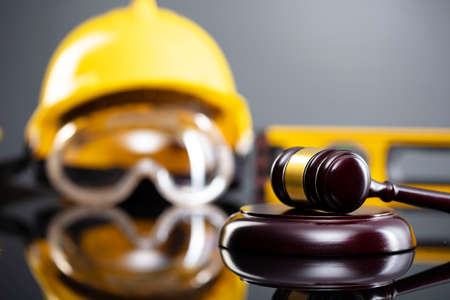 Construction law concept. Helmet and judgeâs gavel on the gray background.の写真素材