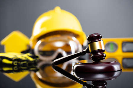 Construction law concept. Helmet and judgeâs gavel on the gray background.の写真素材