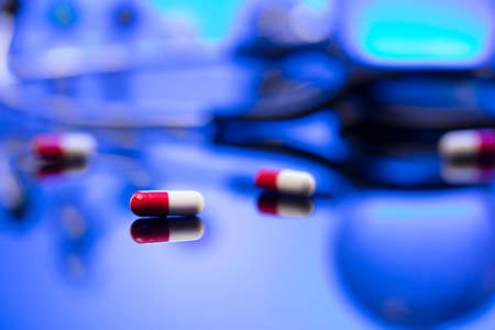 Healthcare concept. Stethoscope and medicines. Blue table and background.の写真素材
