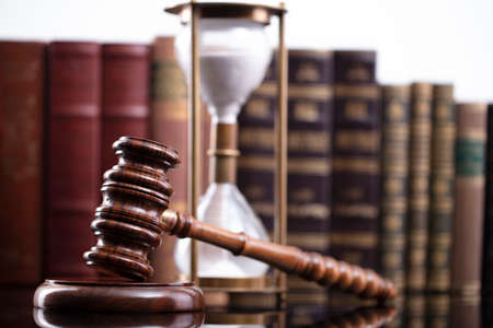 Law theme. Judge chamber. Judgeâ€™s gavel and collection of legal books on the brown desk and...