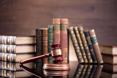 Law theme. Judge chamber. Judgeâ€™s gavel and collection of legal books on the brown desk and...