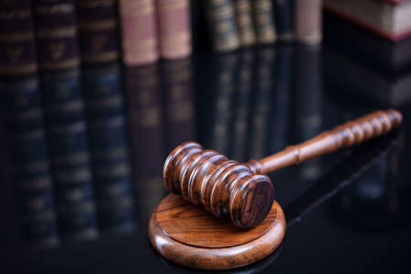 Law theme. Judge chamber. Judgeâ€™s gavel and collection of legal books on the brown desk and...