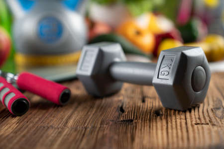 Fitness concept. Healthy nutrition: fruits and vegetables. Equipment for fitness exercises: weighing machine and dumbbells.の写真素材