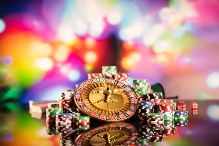 Casino theme.  Roulette wheel, poker chips and dice on  colorful bokeh background.の写真素材