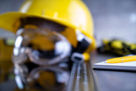 Contractor concept. Tool kit of the contractor: yellow hardhat, libella and tools on the gray...