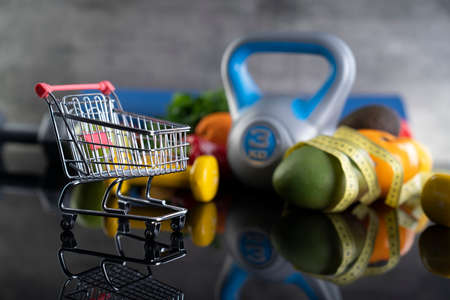 Fitness concept.  Equipment for fitness exercises: weighing machine and dumbbells. Gray background.の写真素材