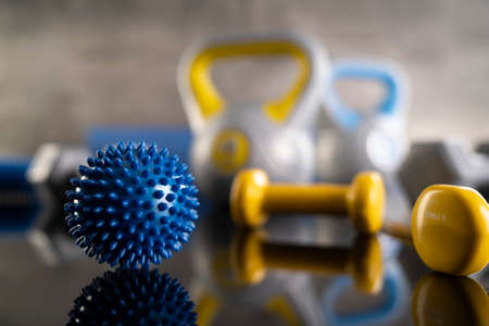 Fitness concept.  Equipment for fitness exercises: weighing machine and dumbbells. Gray background.