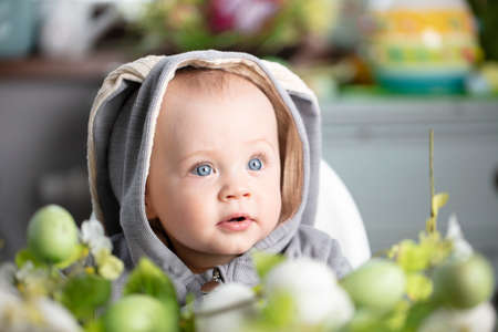 Easter time. Portrait of beautiful little baby boy with easter decorations.の写真素材