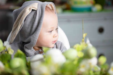 Easter time. Portrait of beautiful little baby boy with easter decorations.の写真素材