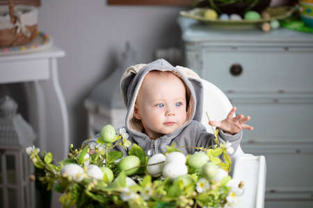 Easter time. Portrait of beautiful little baby boy with easter decorations.の写真素材