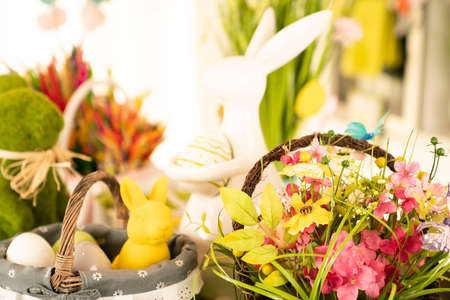 Easter decorations in the house. Easter bunny, easter eggs in basket and cabbage leaf. Bouquets of spring flowers.の写真素材