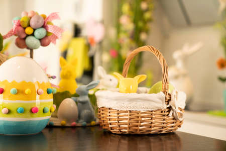 Easter decorations in the house. Easter bunny, easter eggs in basket and cabbage leaf. Bouquets of spring flowers.の写真素材