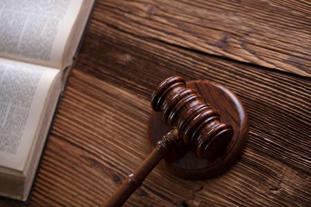 Law theme. Lawyers office. Gavel on the rustic brown desk.