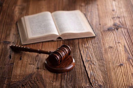 Law theme. Lawyers office. Gavel on the rustic brown desk.