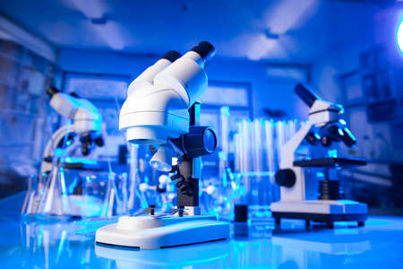 pandemic theme. Science research concerning fast  tests and anti-vaccine. Microscope, beakers and test tubes in the scientific laboratory.の写真素材