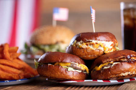 Fourth of July celebration. American flag and decorations. Burgers on rustic wooden table.の写真素材