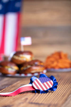 Fourth of July celebration. American flag and decorations. Burgers on rustic wooden table.の写真素材