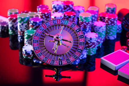 Casino theme.  Roulette wheel, cards, poker chips and dice on red background.の写真素材