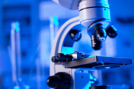 Laboratory investigations concerning covid pandemy. Microscope, glass tubes and beakers in the laboratory.の写真素材