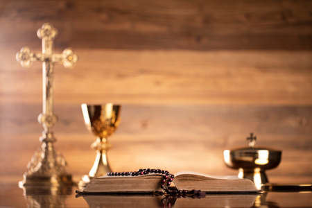 Catholic religion concept. Catholic symbols composition. The Cross, monstrance,  Holy Bible and golden chalice on brown background.の写真素材