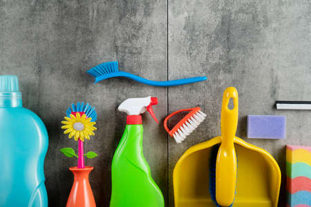 Autumn cleaning. Colorful set of bottles with clining liquids and colorful cleaning kit on gray tiles.の写真素材