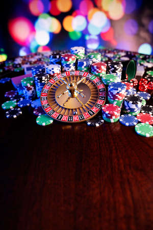Casino theme.  Roulette wheel, poker chips and dice on  colorful bokeh background.の写真素材