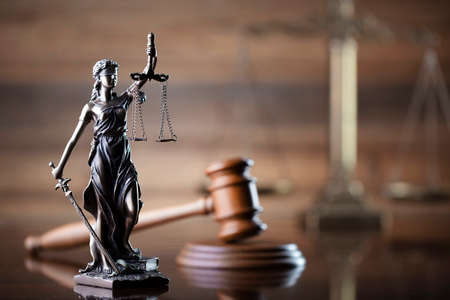 Law symbols composition on brown background. Gavel, scale and Themis sculpture. Place for text.の写真素材