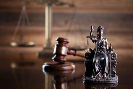 Law symbols composition on brown background. Gavel, scale and Themis sculpture. Place for text.の写真素材