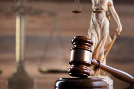 Law symbols composition on brown background. Gavel, scale and Themis sculpture. Place for text.の写真素材