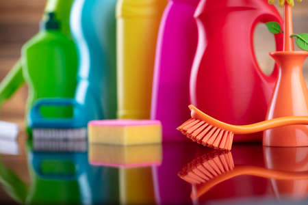 Autumn cleaning. Colorful set of bottles with clining liquids and colorful cleaning kit on brown background.の写真素材