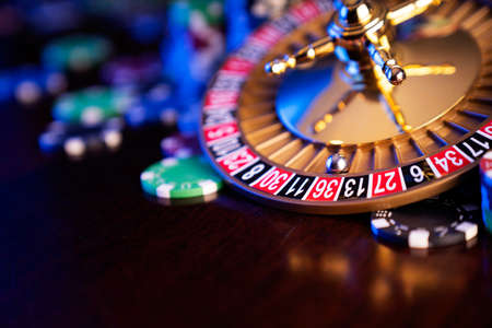 Casino theme.  Roulette wheel and poker chips on  colorful bokeh background.の写真素材