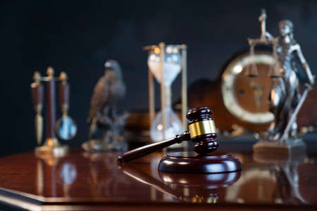 The law concept background.  Gavel of  the judge, Themis statue, the clock and the scale on the gray...