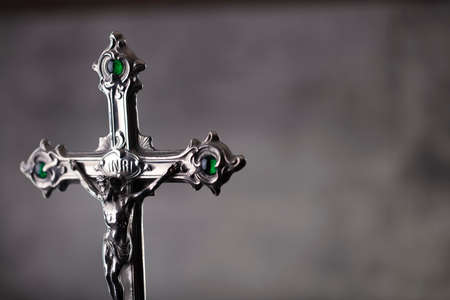 Catholic religion concept. Catholic symbols composition. The Cross, monstrance,  Holy Bible and golden chalice on wooden altar and gray background.の写真素材