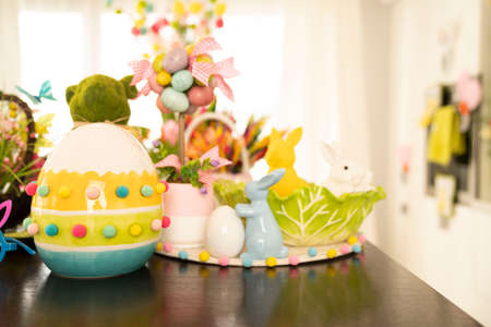Easter time. Easter decorations on the shining wooden table. Easter bunny, easter eggs in basket and...