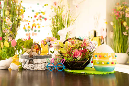 Easter time. Easter decorations on the shining wooden table. Easter bunny, easter eggs in basket and cabbage leaf.の写真素材