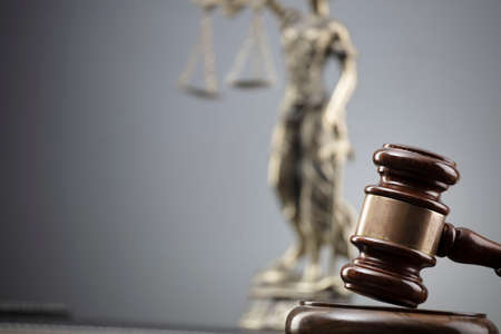 Law and justice concept. War crimes. Gavel, Themis sculpture and scale in lawyers office. Gray...